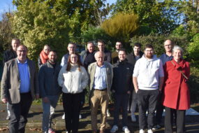 Des pêrsonnes devant une haie