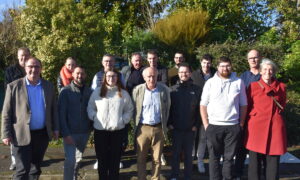 Des pêrsonnes devant une haie