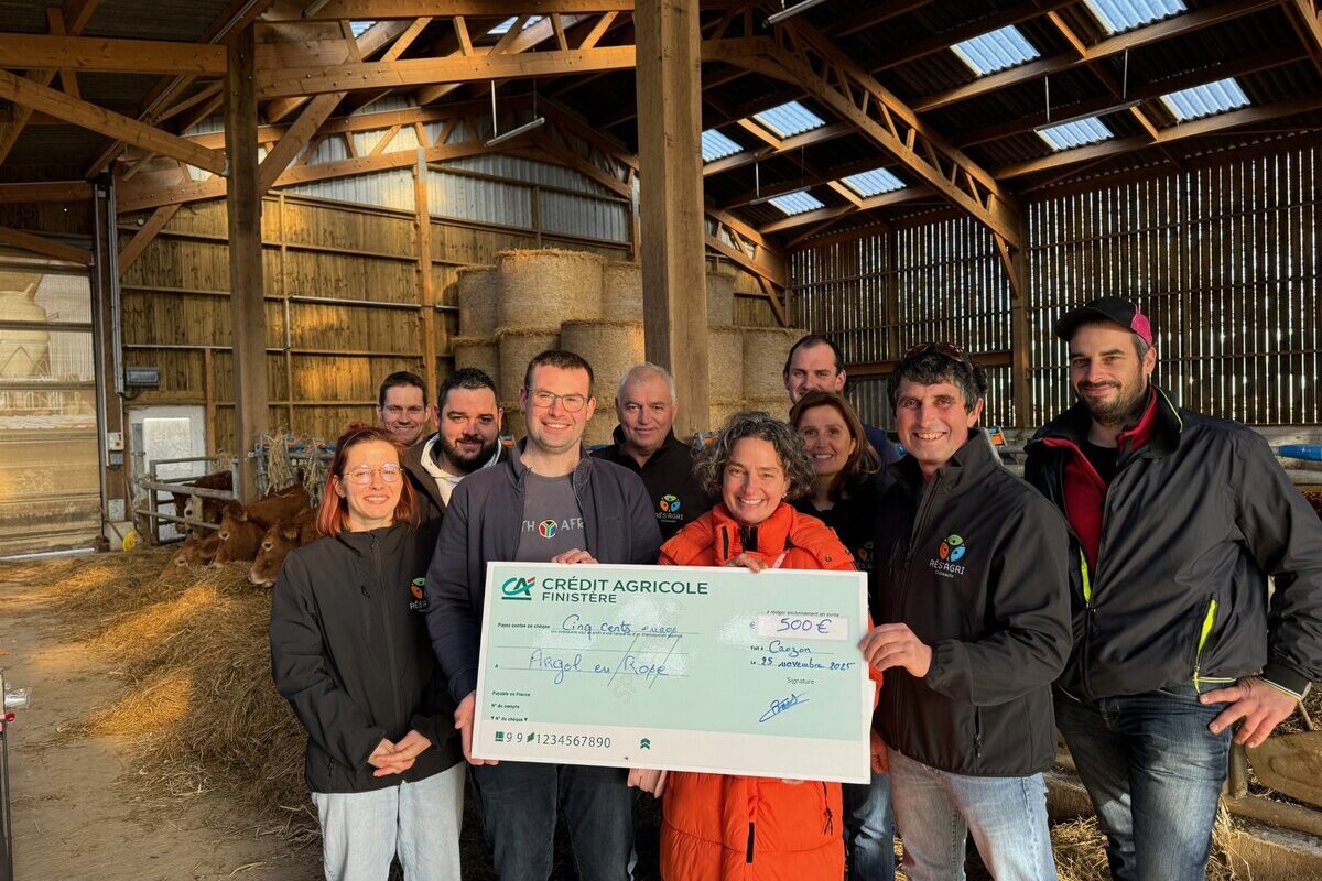 Des personnes dans une étable avec un imense chèque dans les mains - Illustration Un élan de solidarité sur le territoire de Châteaulin