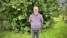 Un homme avec les bras dans le dos dans un jardin