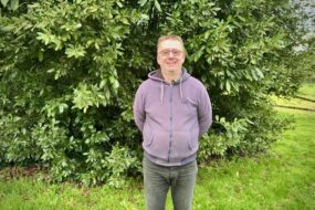 Un homme avec les bras dans le dos dans un jardin