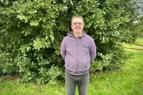 Un homme avec les bras dans le dos dans un jardin