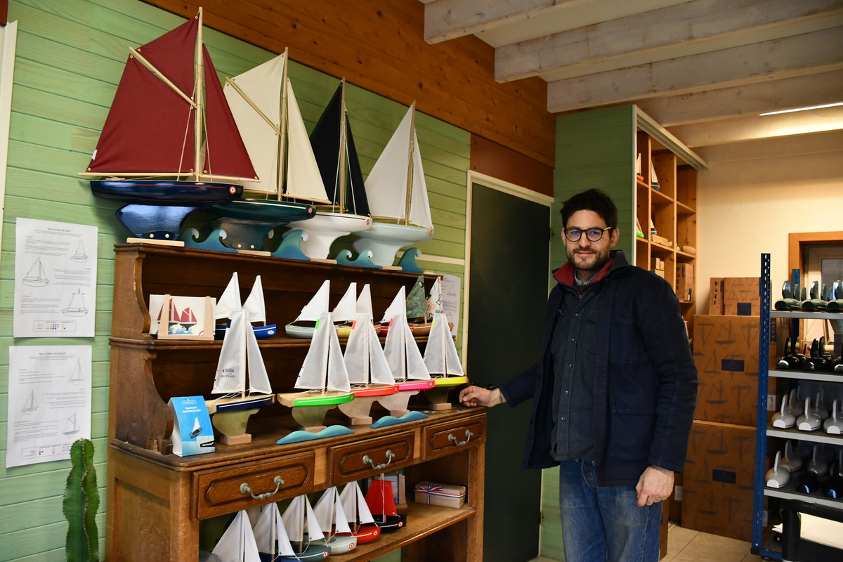 Augustin Hubert devant quelques modèles de ses bateaux-jouets.