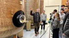 Des personnes devant des cuves de fermentation