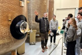 Des personnes devant des cuves de fermentation