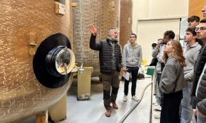Des personnes devant des cuves de fermentation