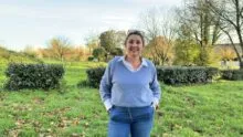 Une femme avec les mains dans les poches dans un jardin