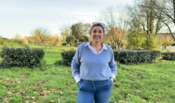Une femme avec les mains dans les poches dans un jardin