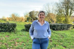 Une femme avec les mains dans les poches dans un jardin