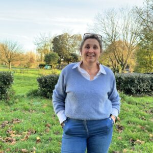Une femme avec les mains dans les poches dans un jardin