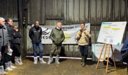 Des hommes rassemblés dans un bâtiment d'élevage laitier