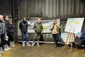 Des hommes rassemblés dans un bâtiment d'élevage laitier
