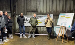 Des hommes rassemblés dans un bâtiment d'élevage laitier