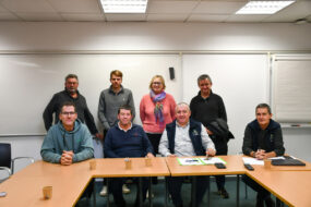 Des personnes dans une salle, une rangée assise devant et l'autre debout derrière