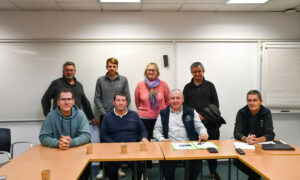 Des personnes dans une salle, une rangée assise devant et l'autre debout derrière