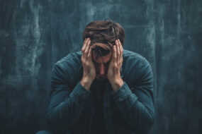 un homme se tient la tête dans les mains
