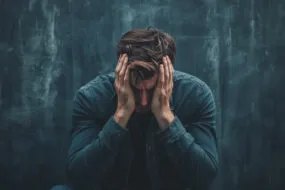 un homme se tient la tête dans les mains