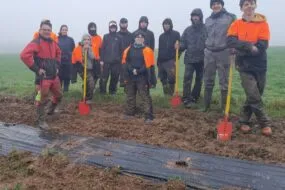Un groupe de personnes en train de planter des haies