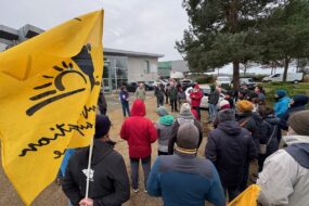 Un rassemblement de personne avec des drapeux de la Confédération Paysanne
