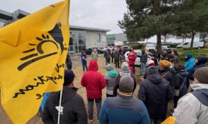 Un rassemblement de personne avec des drapeux de la Confédération Paysanne