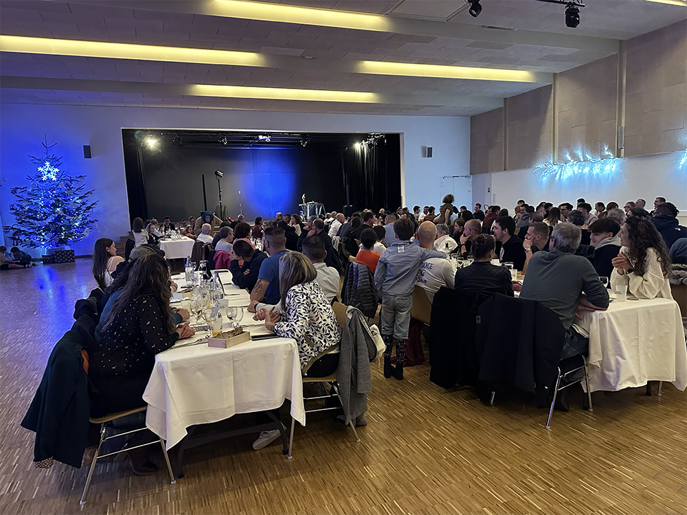 Des personnes dans une salle pour un repas de Noël - Illustration Une belle réussite pour l’arbre de Noël des salariés