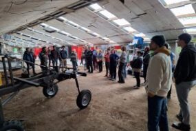 Des personnes dans un hangar autour de machines agricoles