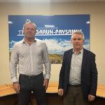 Deux hommes devant une affiche Garun-Paysanne