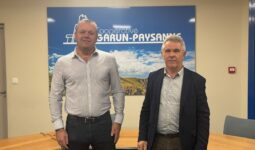 Deux hommes devant une affiche Garun-Paysanne