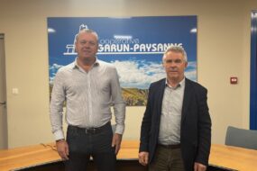 Deux hommes devant une affiche Garun-Paysanne