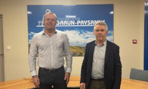 Deux hommes devant une affiche Garun-Paysanne