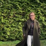 Une jeune femme devant une haie