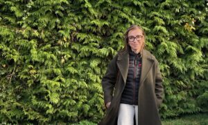 Une jeune femme devant une haie