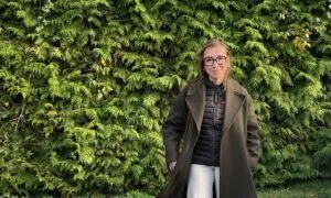 Une jeune femme devant une haie