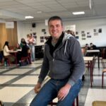 Un homme souriant dans le foyer d'un établissement scolaire