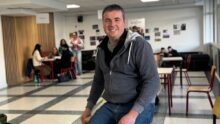 Un homme souriant dans le foyer d'un établissement scolaire