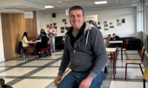 Un homme souriant dans le foyer d'un établissement scolaire