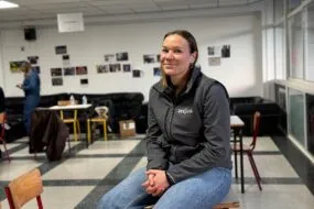 Une femme assise sur une table dans le foyer d'un établissement scolaire