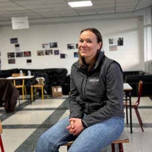 Une femme assise sur une table dans le foyer d'un établissement scolaire