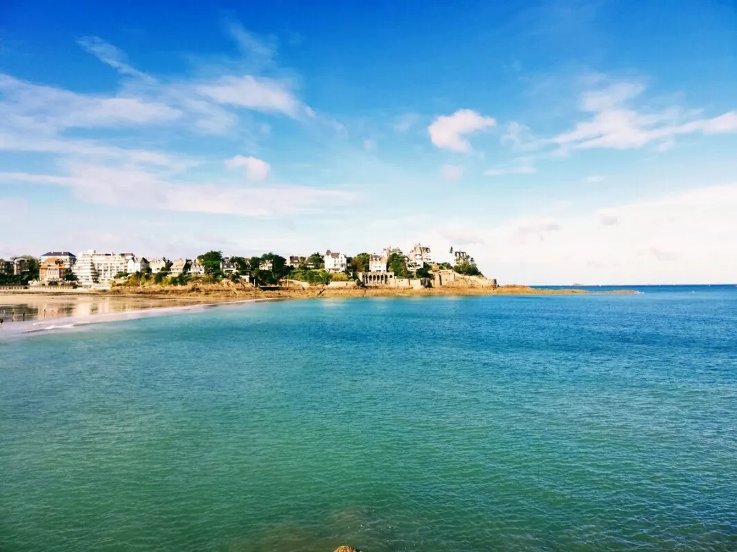 Une mer paisible et bleu avec en arrière plan une ville sur la côte