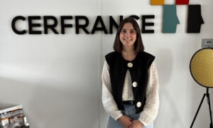 Une jeune femme pose devant un mur avec le logo Cerfrance