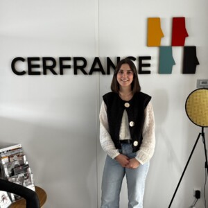 Une jeune femme pose devant un mur avec le logo Cerfrance