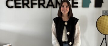 Une jeune femme pose devant un mur avec le logo Cerfrance