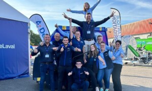 Des commerciaux font une pyramide humaine sur un parking d'une concession agricole