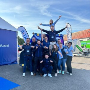 Des commerciaux font une pyramide humaine sur un parking d'une concession agricole