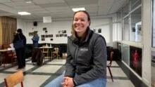 une femme assise sur une table dans une salle de classe