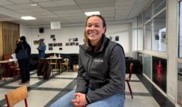 une femme assise sur une table dans une salle de classe