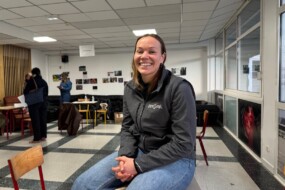 une femme assise sur une table dans une salle de classe