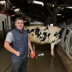 Un inséminateur souriant dans un bâtiment d'élevage de vaches