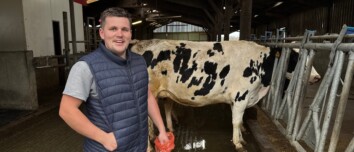 Un inséminateur souriant dans un bâtiment d'élevage de vaches
