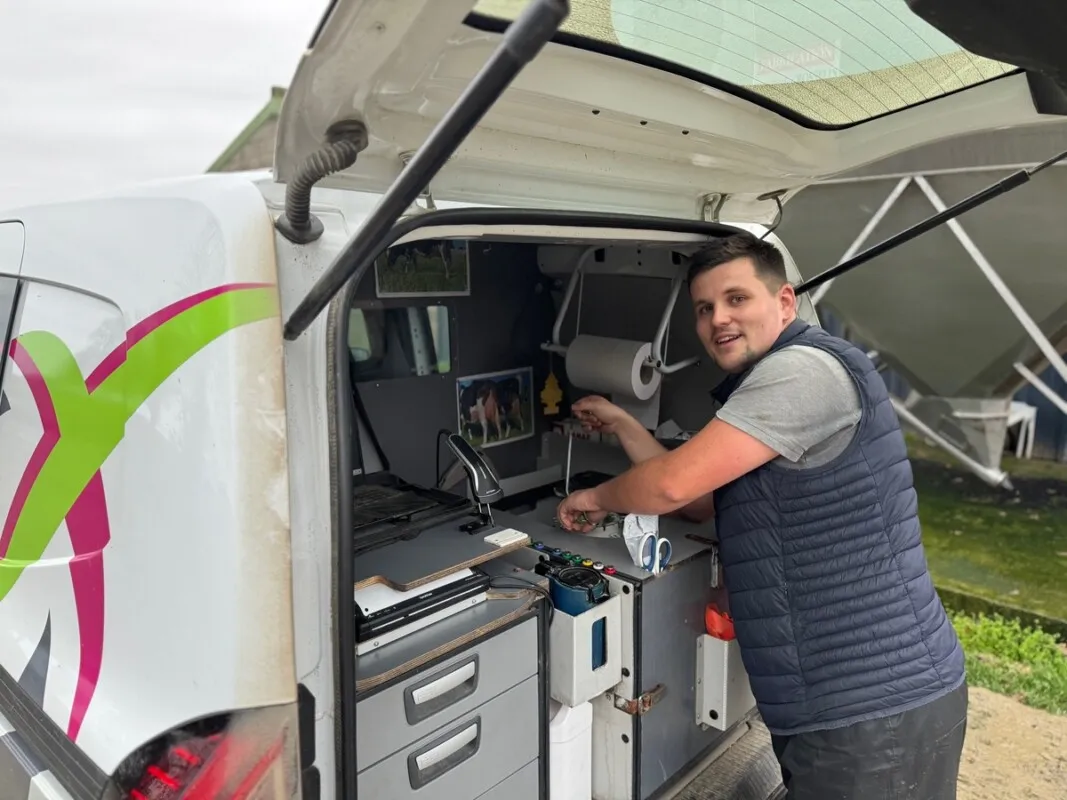 Un homme à l'arrière de sa camionnette aménager pour son activité d'inséminateur